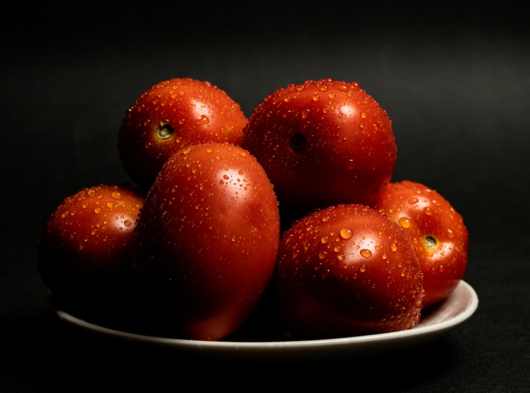 red round fruits on white ceramic bowl