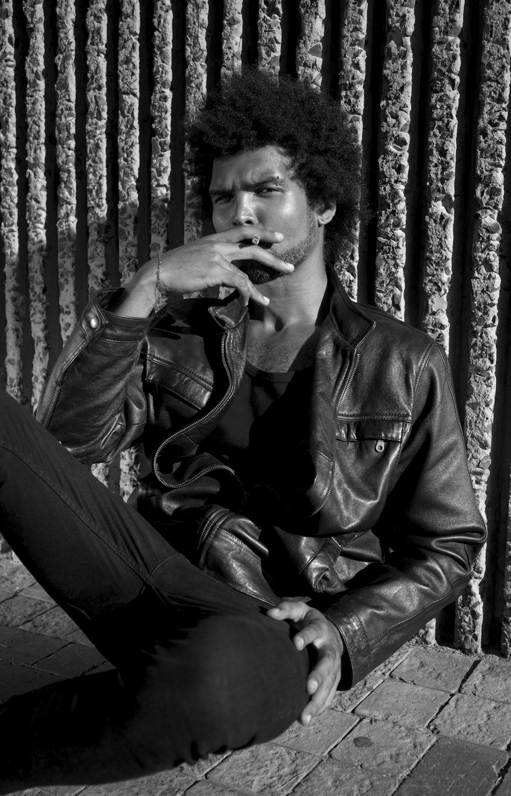 man in black leather jacket smoking cigarette