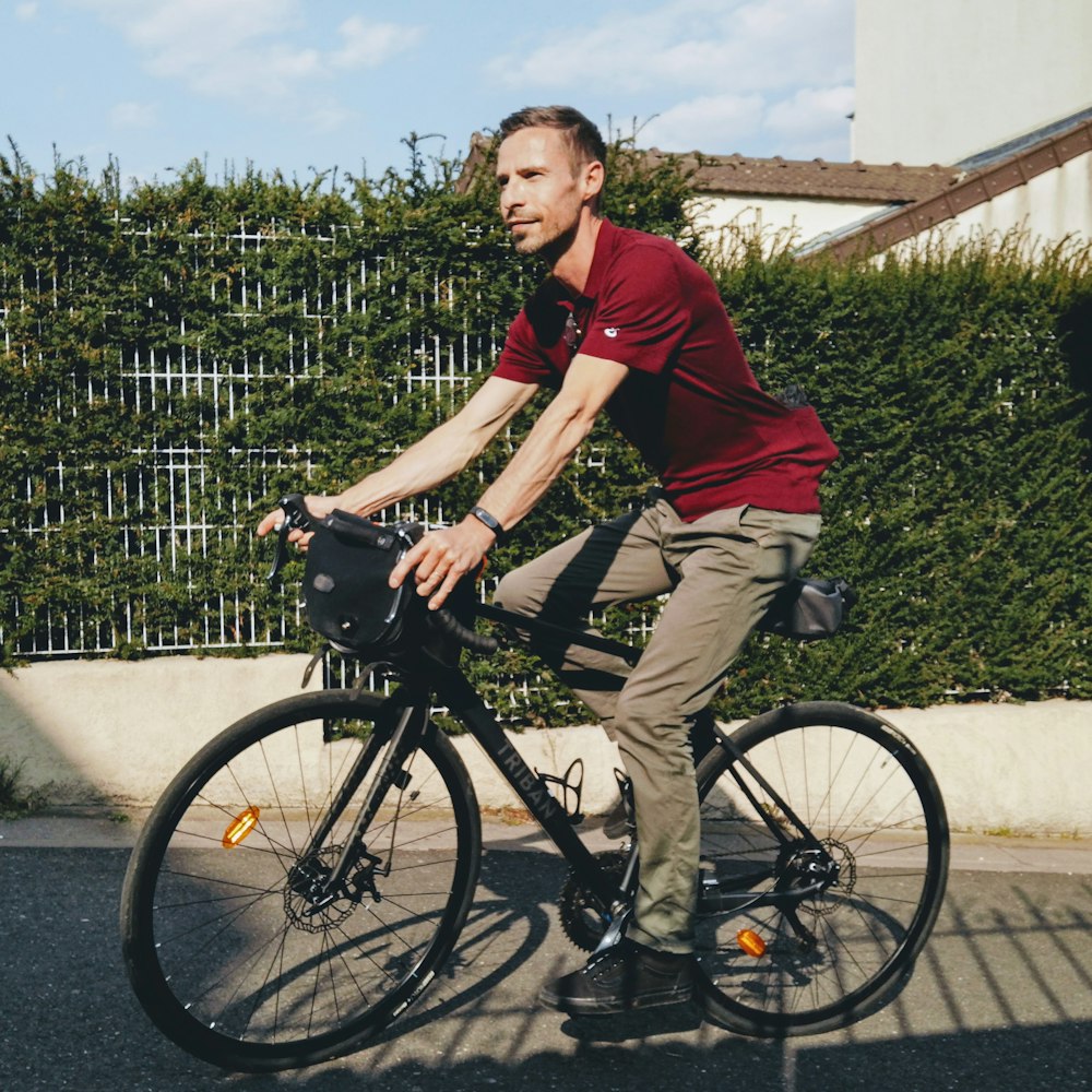 man in red polo shirt riding on black bicycle