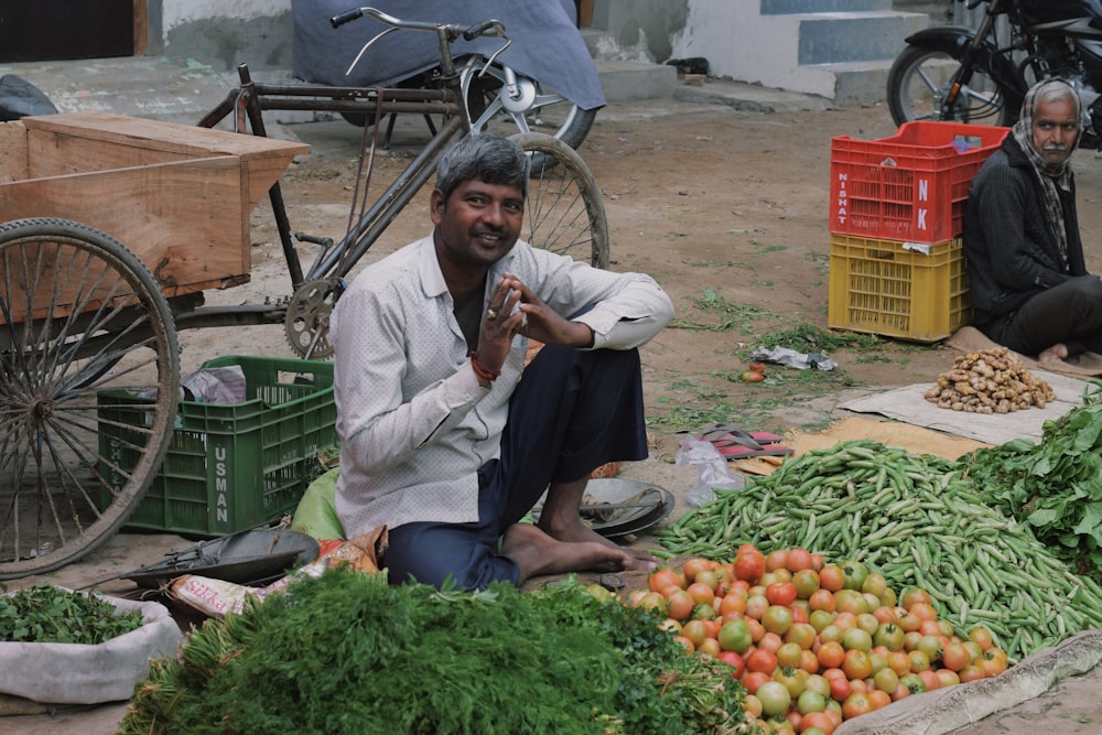 homme en polo gris assis sur une chaise près des fruits