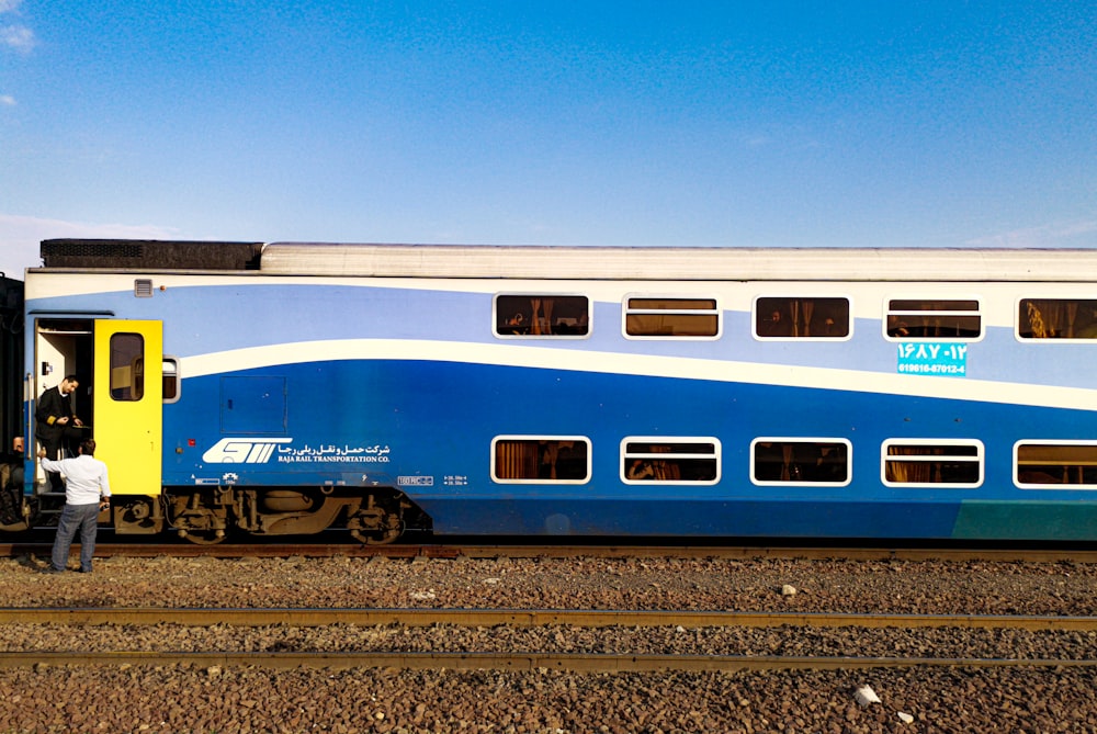 blue and white train on rail tracks during daytime