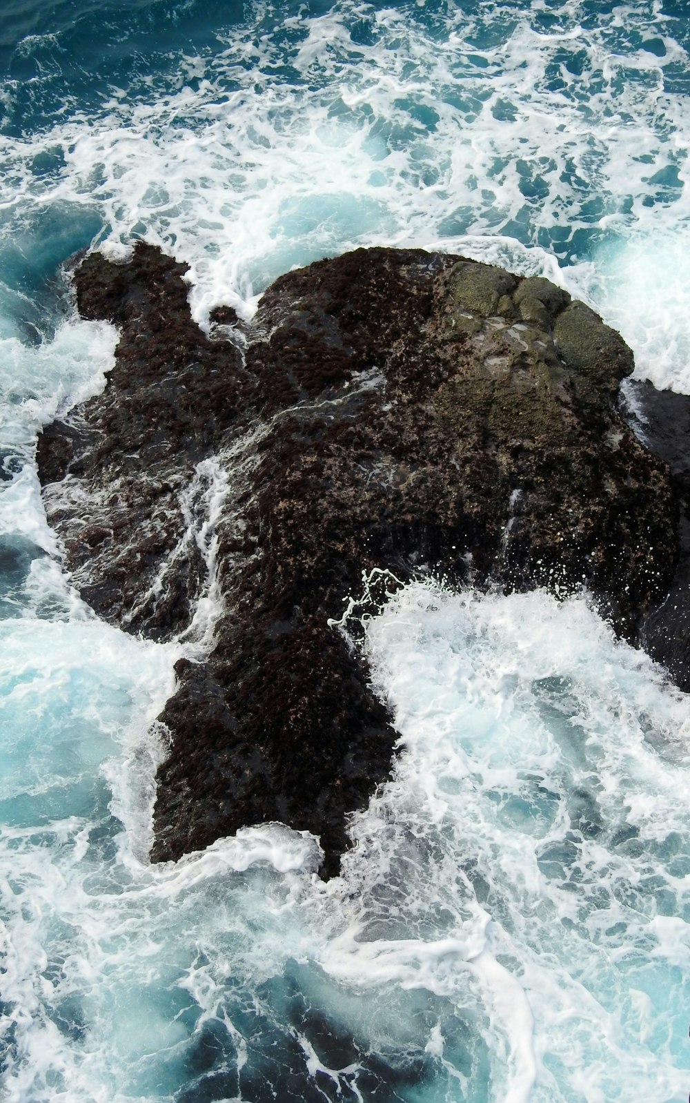 brown rock formation on body of water during daytime