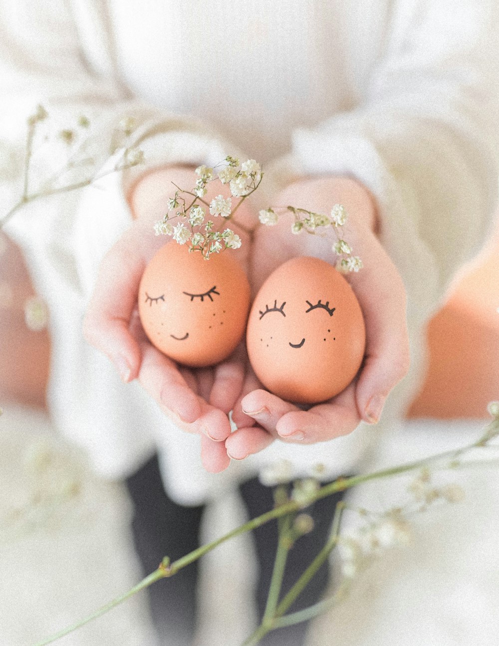 woman in white wedding dress holding two brown eggs