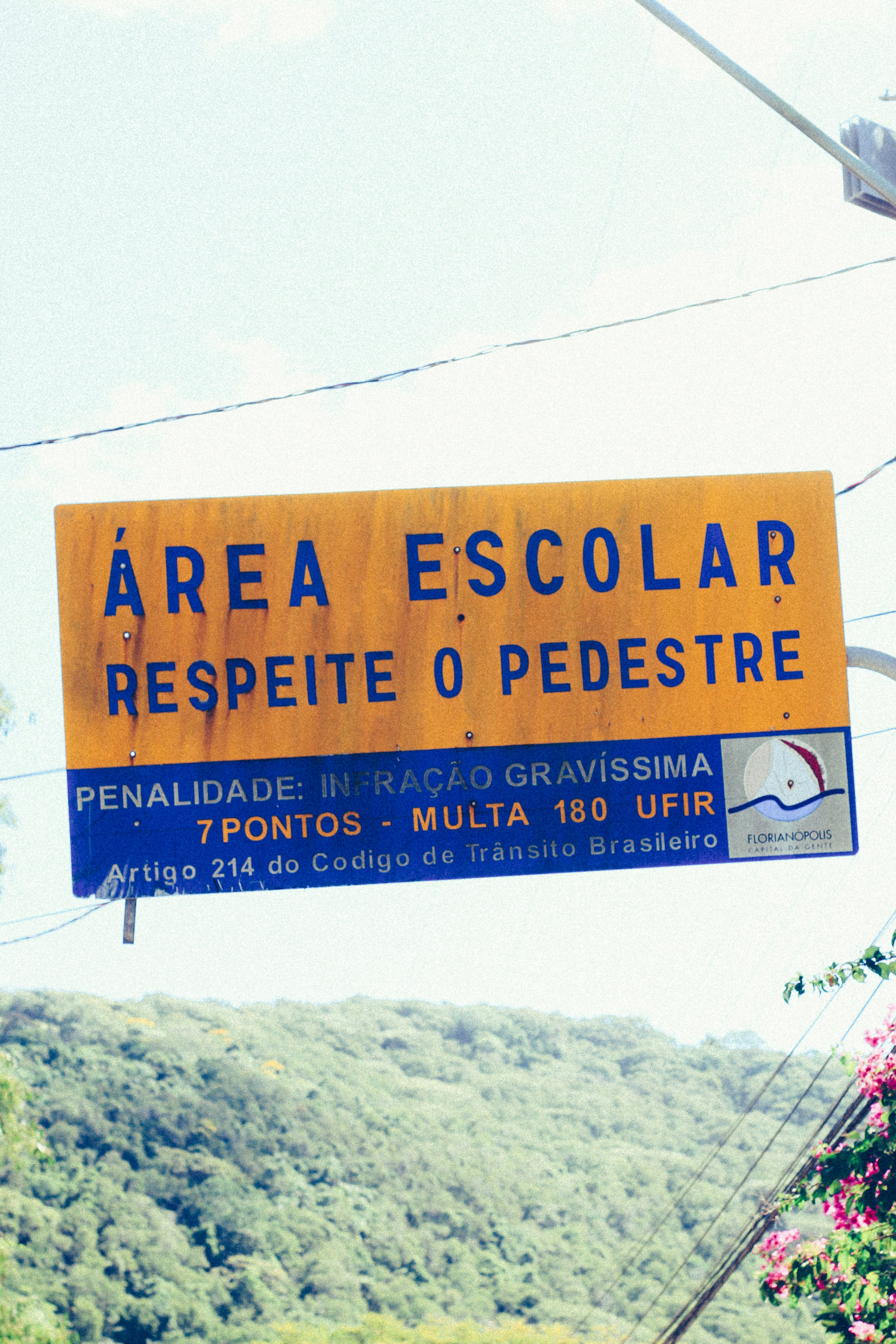 a yellow sign hanging from the side of a road