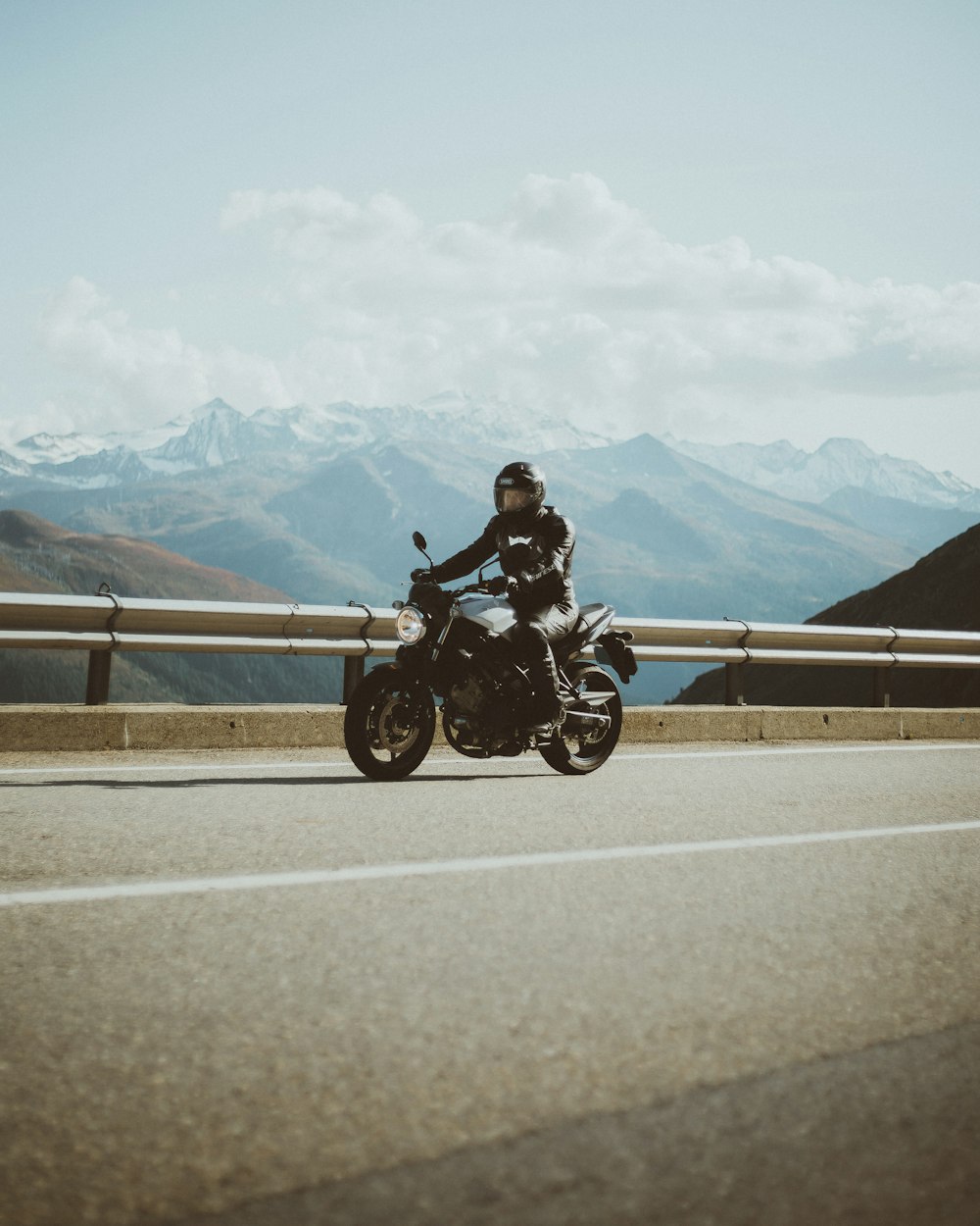 man in black jacket riding motorcycle on road during daytime