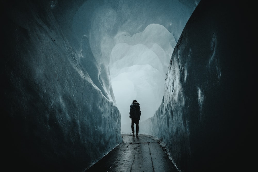 person walking on a pathway in a tunnel