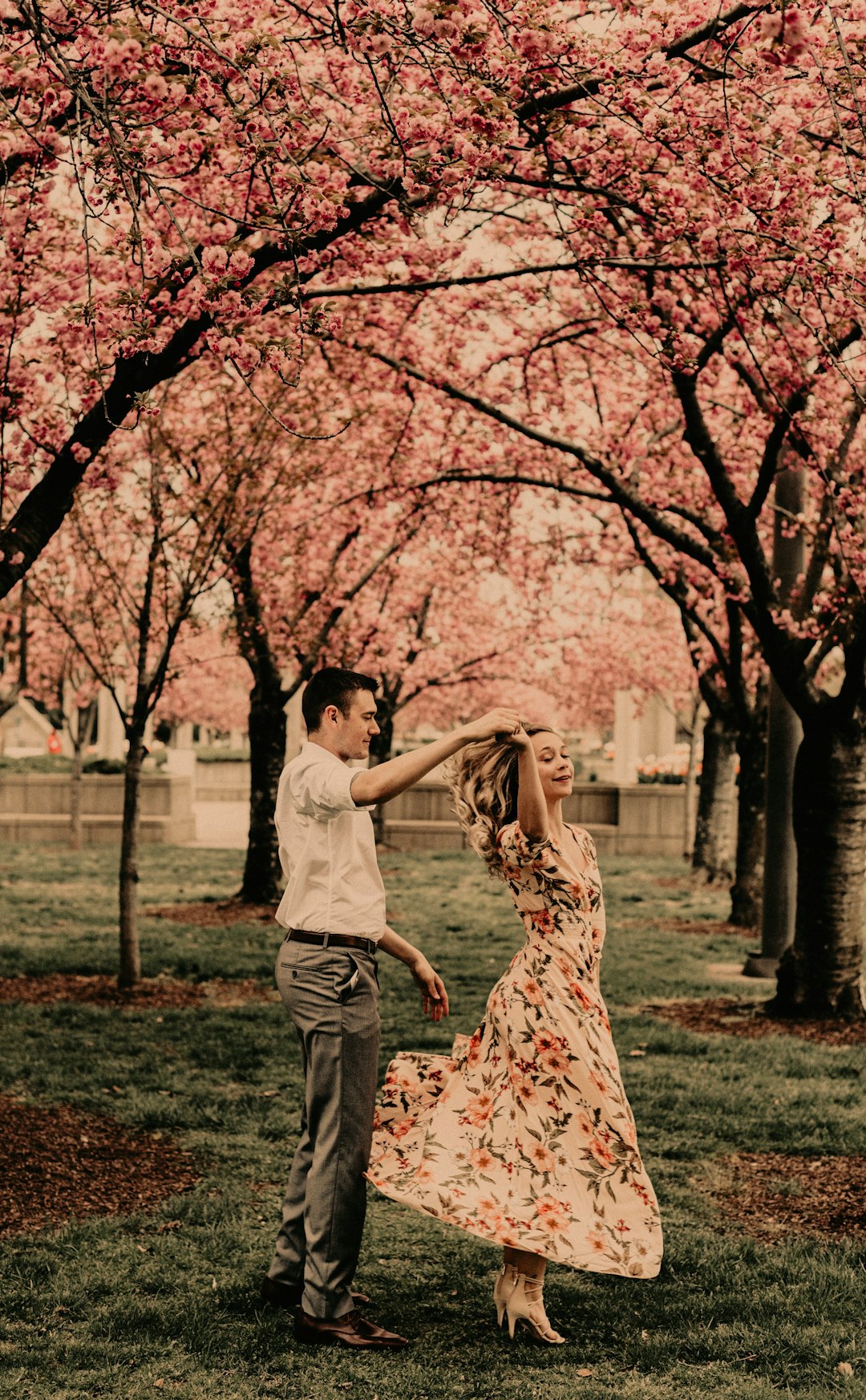 man and woman holding hands while walking on green grass field during daytime