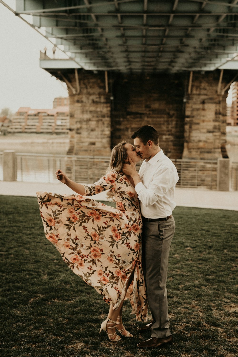 man and woman holding hands while walking on green grass field during daytime