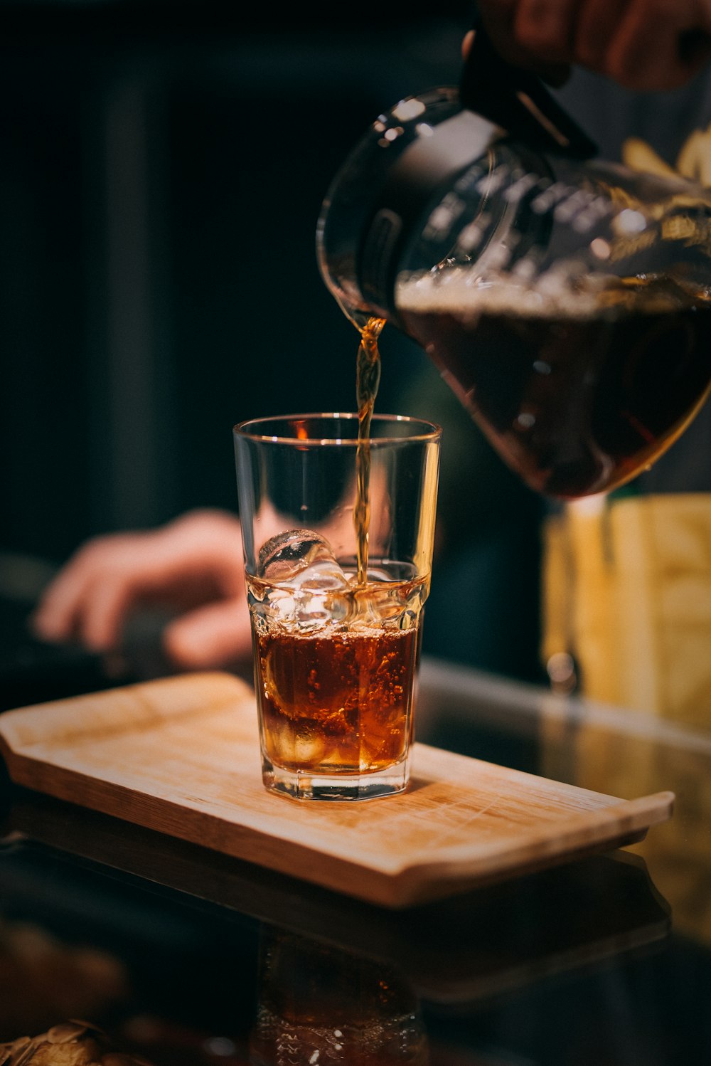 clear drinking glass with brown liquid on brown wooden table