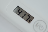 A close-up view of a digital thermometer showing a temperature reading of 41.7°C.