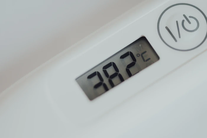 Digital wall thermostat displaying a set temperature