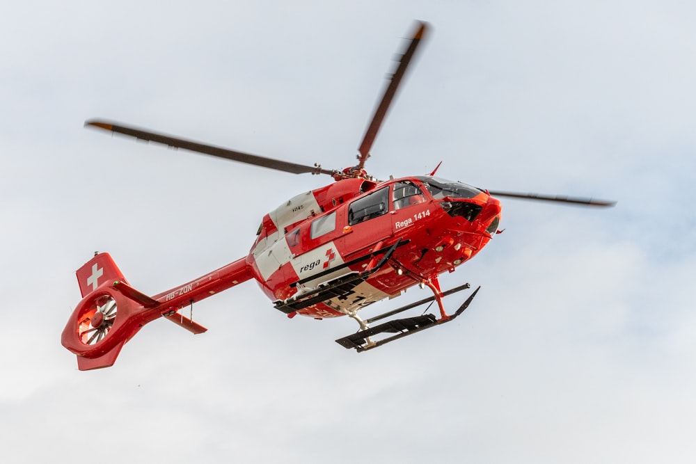 昼間空を飛ぶ赤いヘリコプター