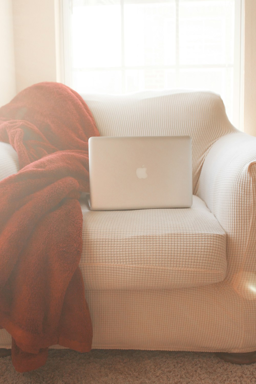 silver macbook on brown textile