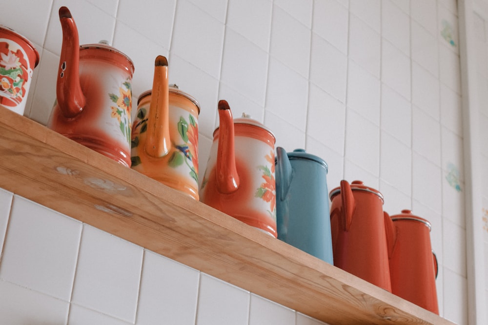 blue and red ceramic mugs on brown wooden shelf
