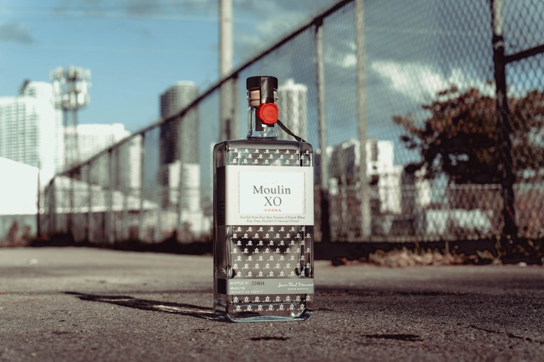 black and white labeled bottle on gray concrete road during daytime