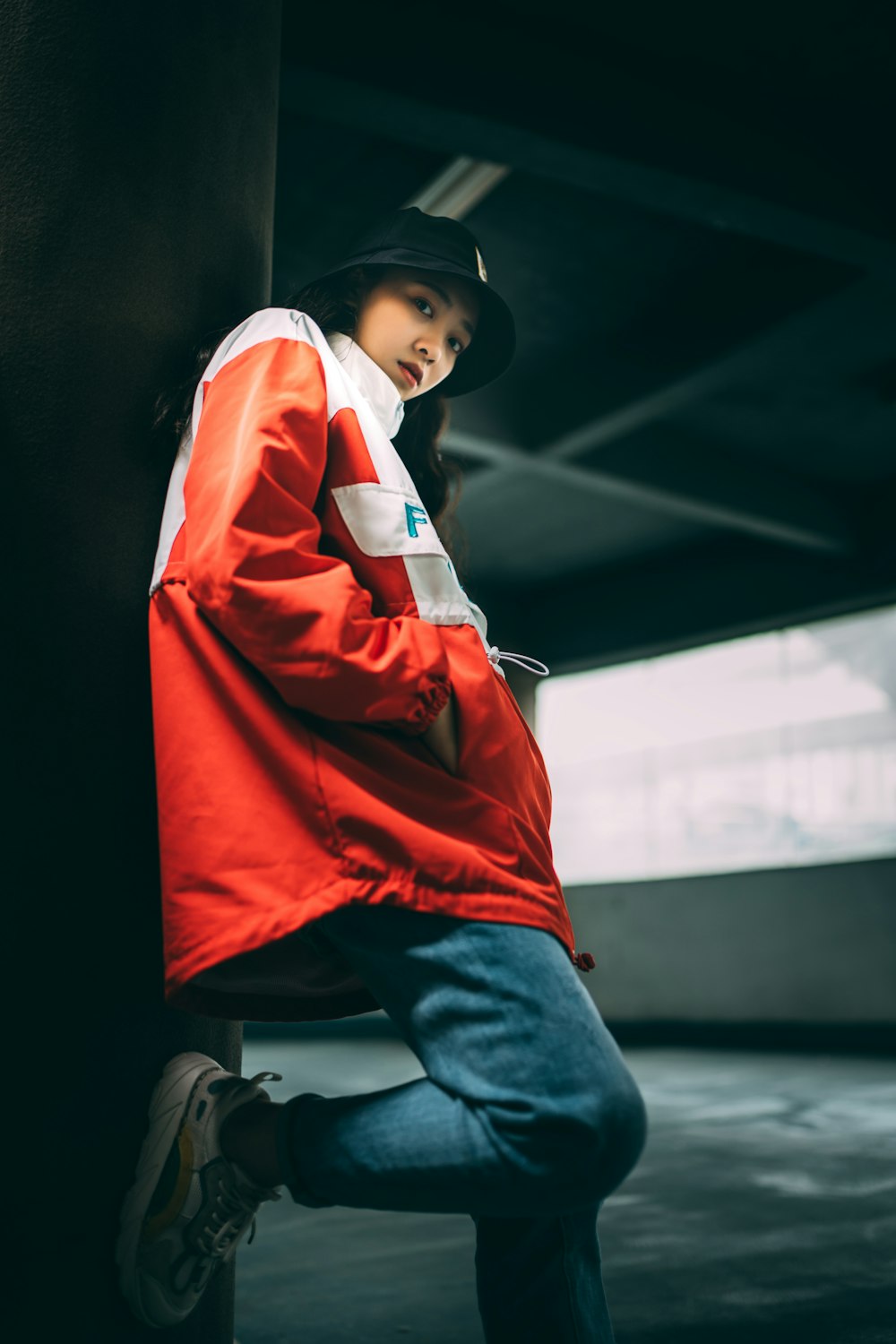 boy in orange jacket and blue denim jeans wearing white headphones