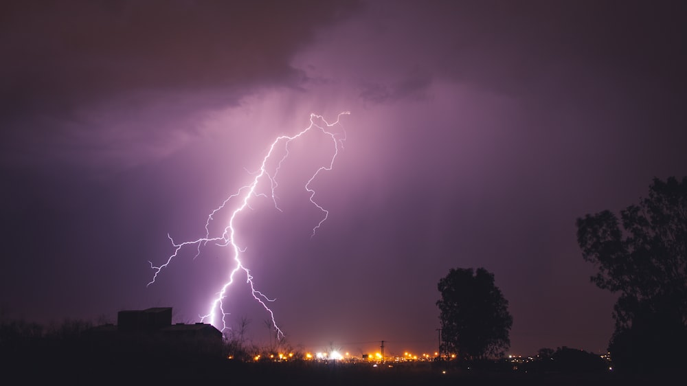 a lightning bolt hitting over a city at night