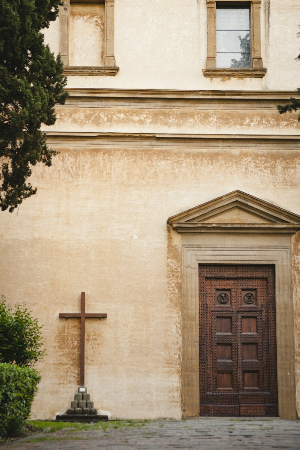 brown wooden cross on beige concrete building