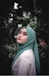 woman in green hijab standing near green plants