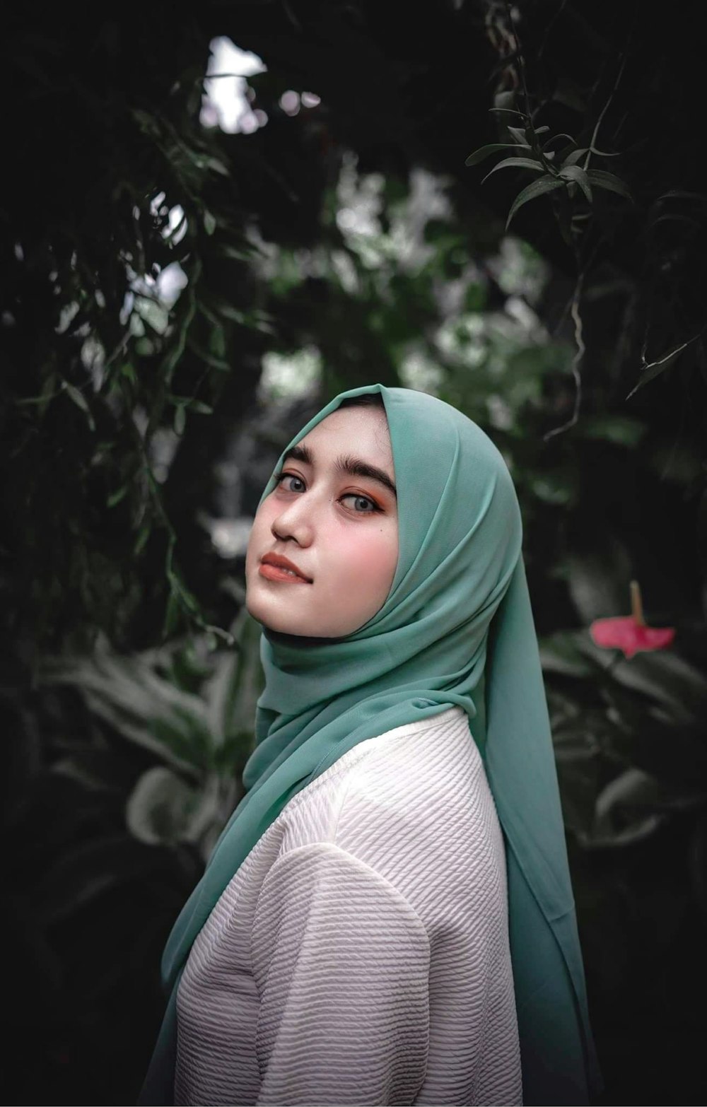 woman in green hijab standing near green plants