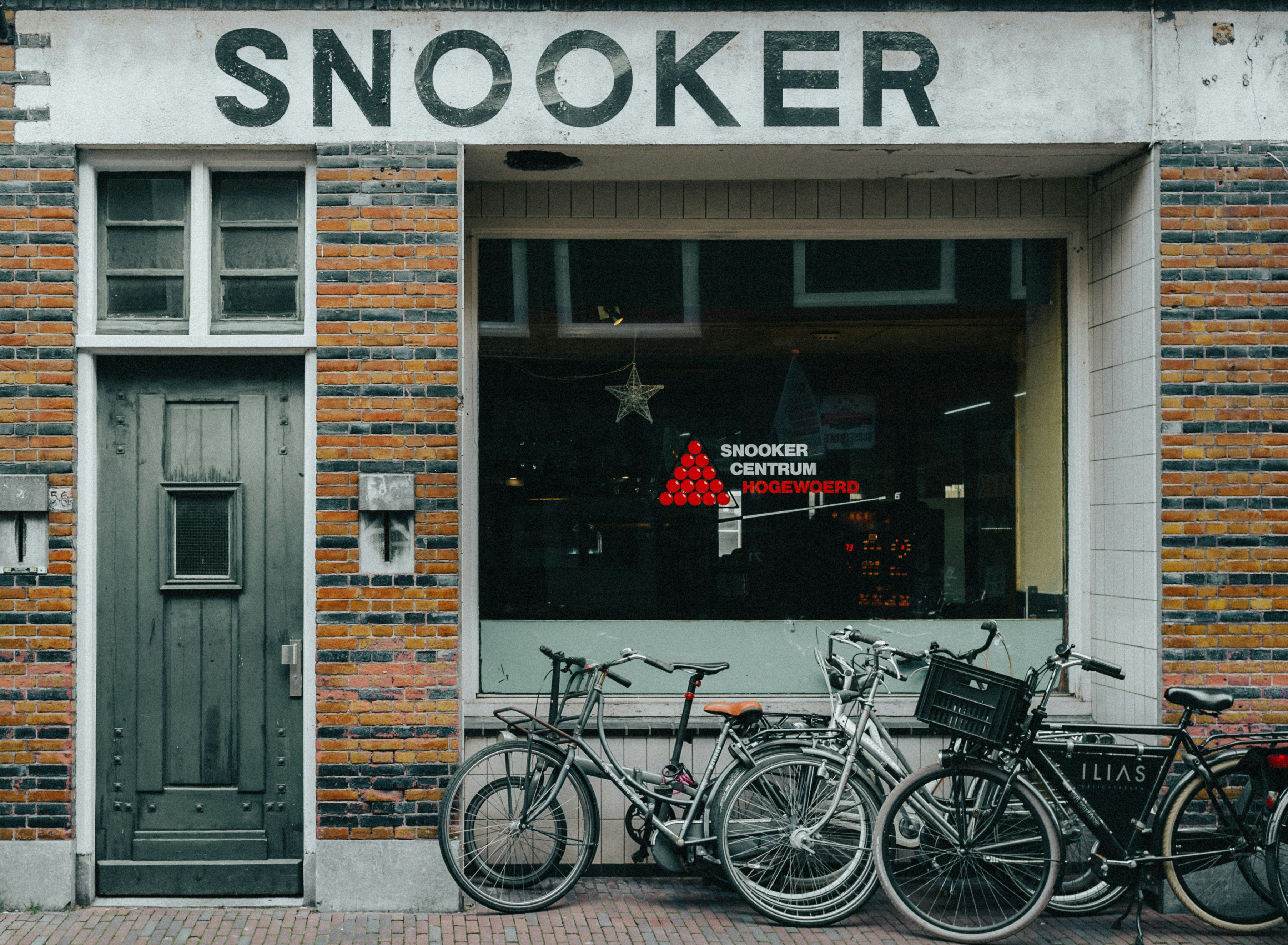black city bike parked beside brown wooden door, 