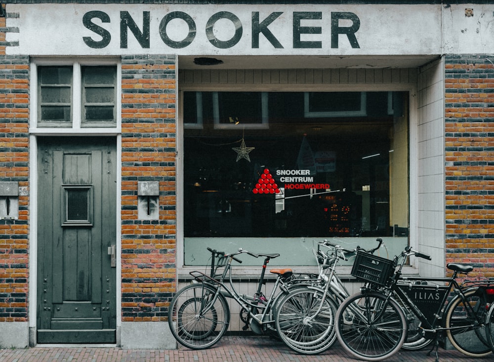 black city bike parked beside brown wooden door