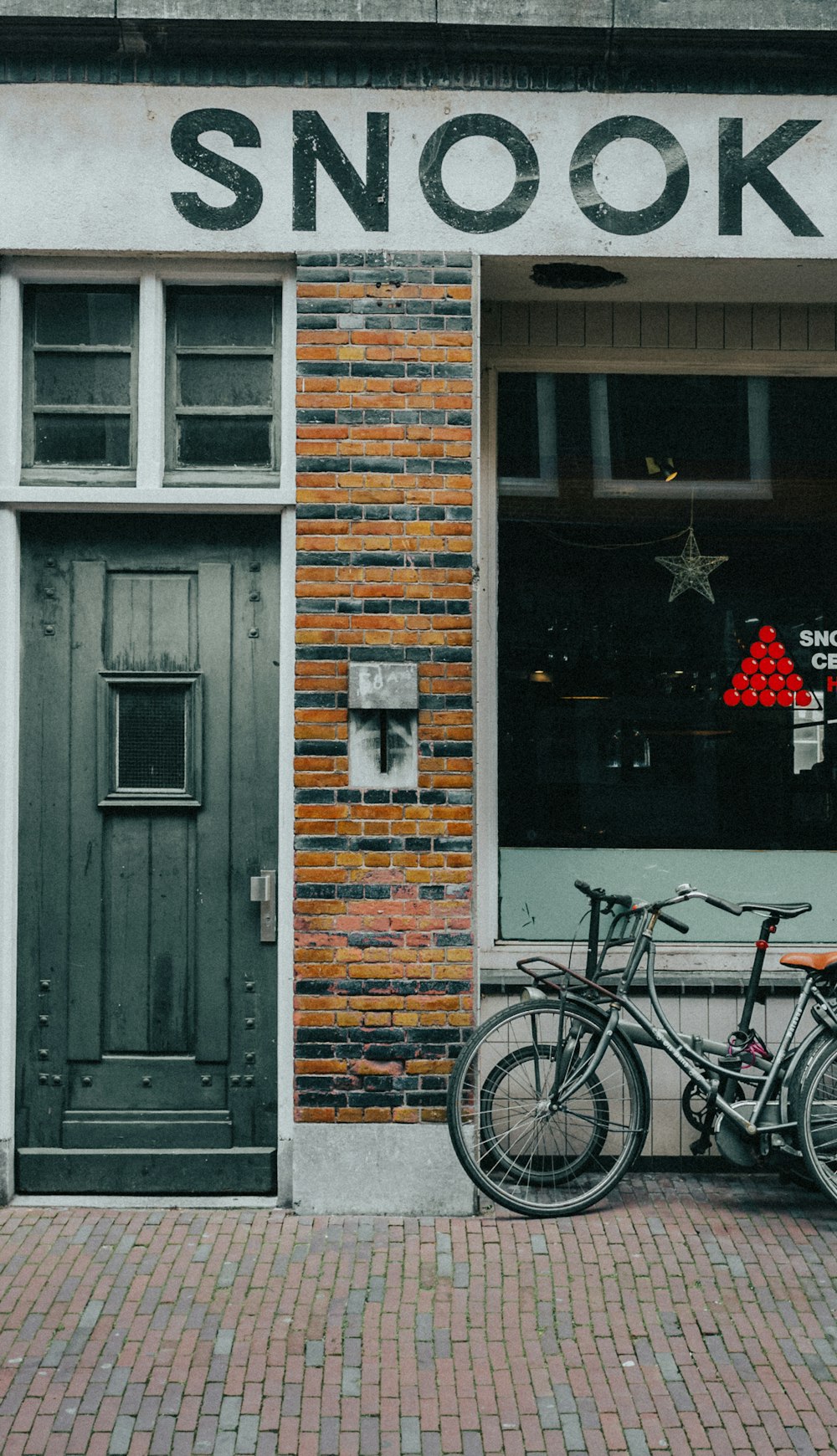 black bicycle parked beside gray wooden door