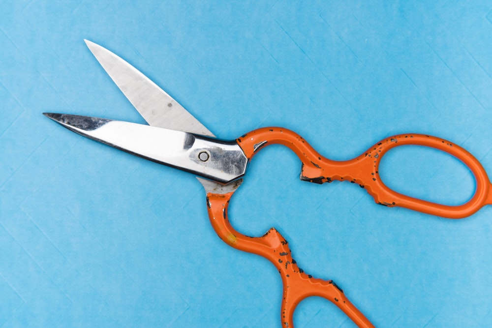 orange handle scissors on blue textile