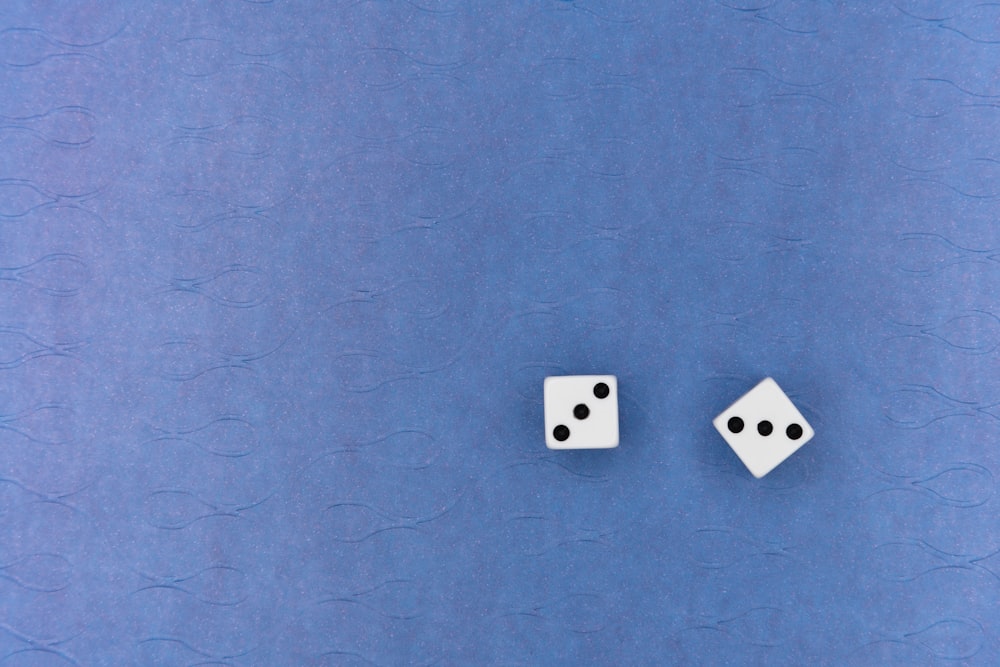 white and black dice on blue textile