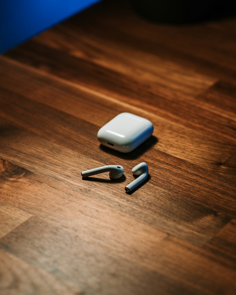 white apple airpods on brown wooden table