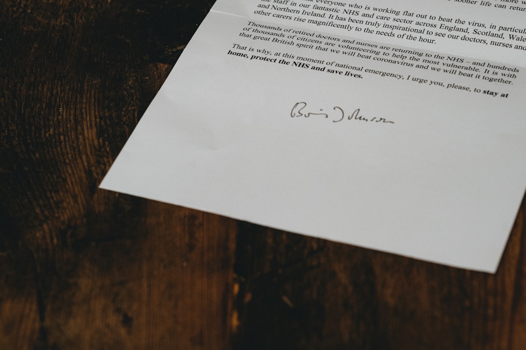 white printer paper on brown wooden table, UK Coronavirus latter from Boris Johnson