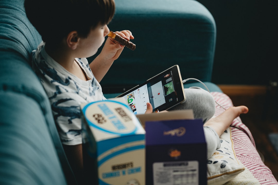 woman in white and blue floral shirt holding black tablet computer