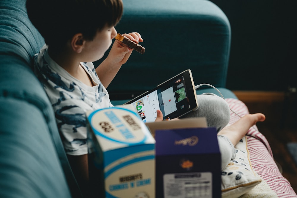 Frau in weiß-blauem Blumenhemd mit schwarzem Tablet-Computer