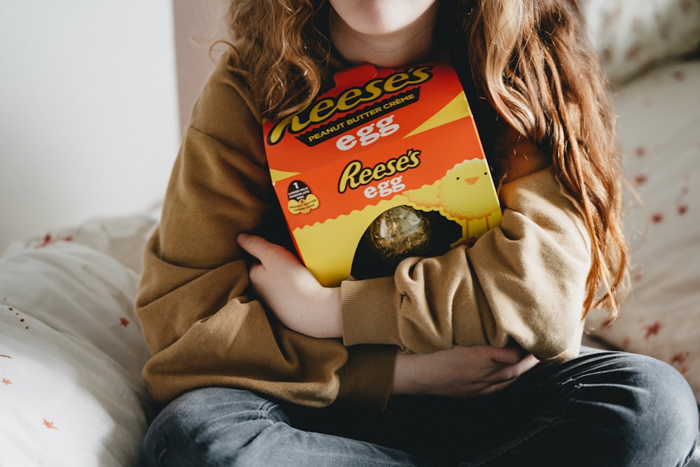 woman in brown long sleeve shirt and blue denim jeans sitting on couch