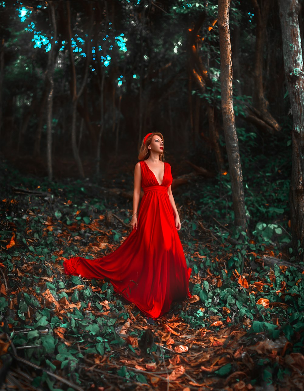 mulher no vestido vermelho de pé em folhas secas
