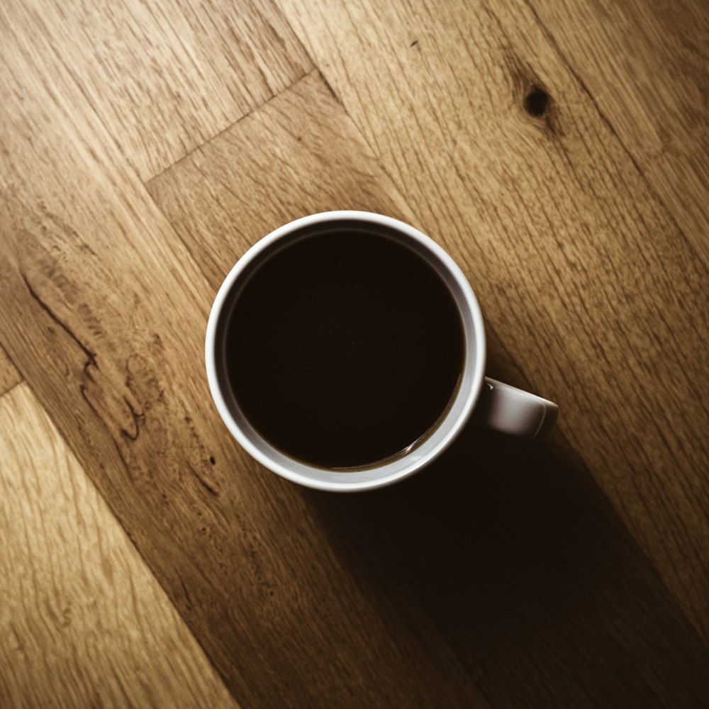 white ceramic mug on brown wooden table