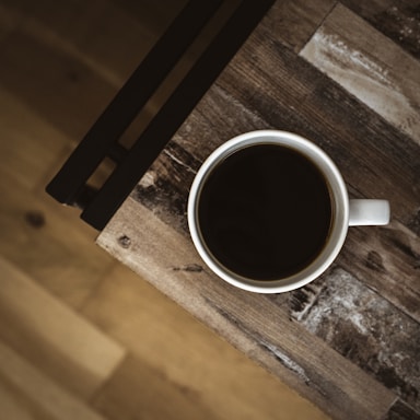 A warm coffee cup placed on a rustic wooden table.