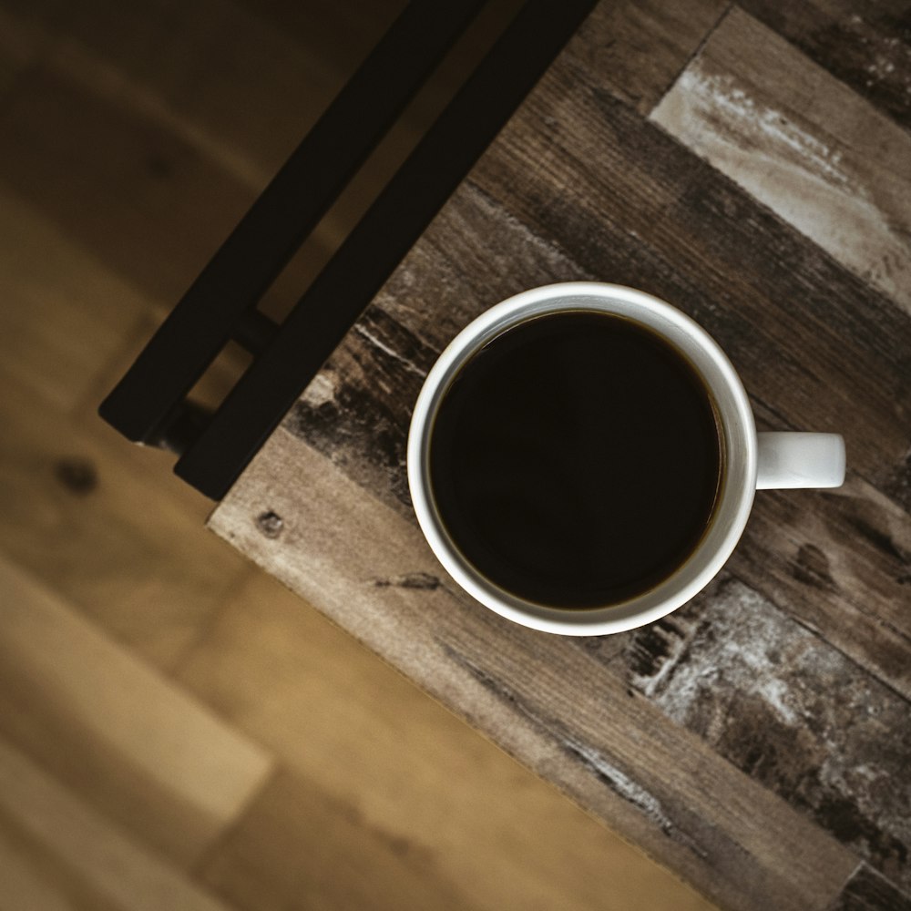 white ceramic mug on brown wooden table