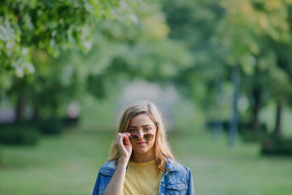 donna in giacca di jeans blu che indossa occhiali da vista con montatura marrone