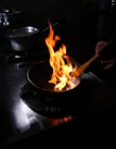 A happy home cook using a stick & fin frying pan on a stovetop, flipping vegetables with ease.