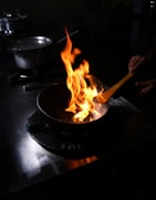 A happy home cook using a stick & fin frying pan on a stovetop, flipping vegetables with ease.