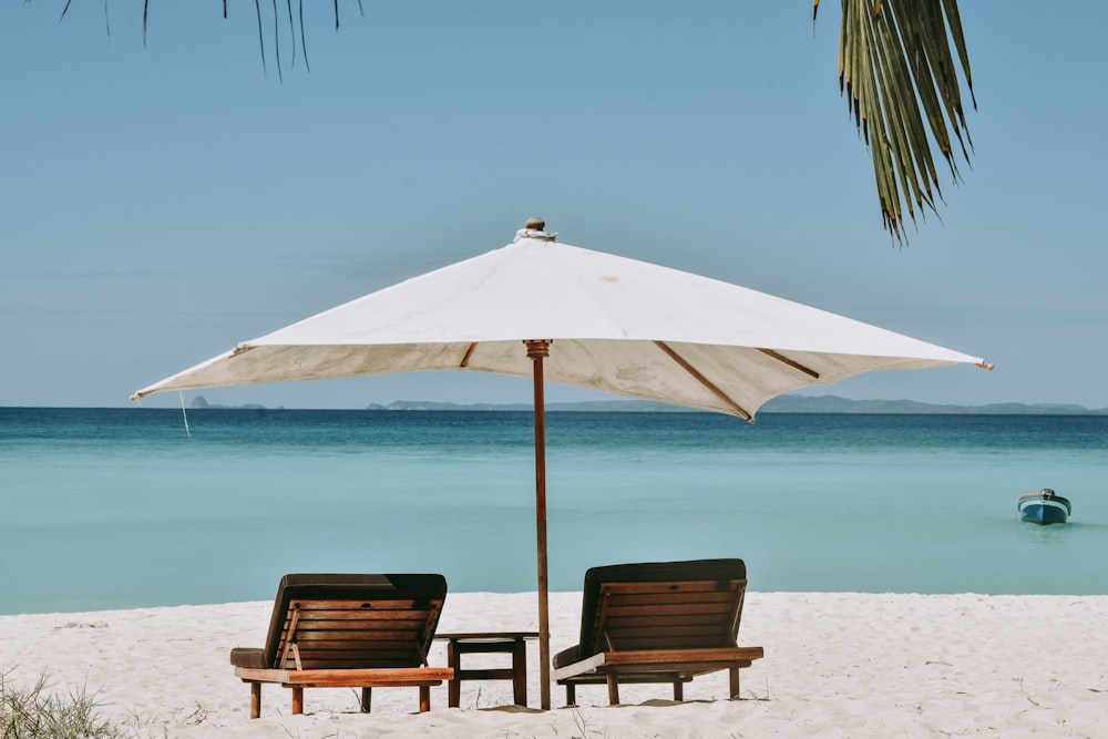 two brown wooden armchairs on beach during daytime