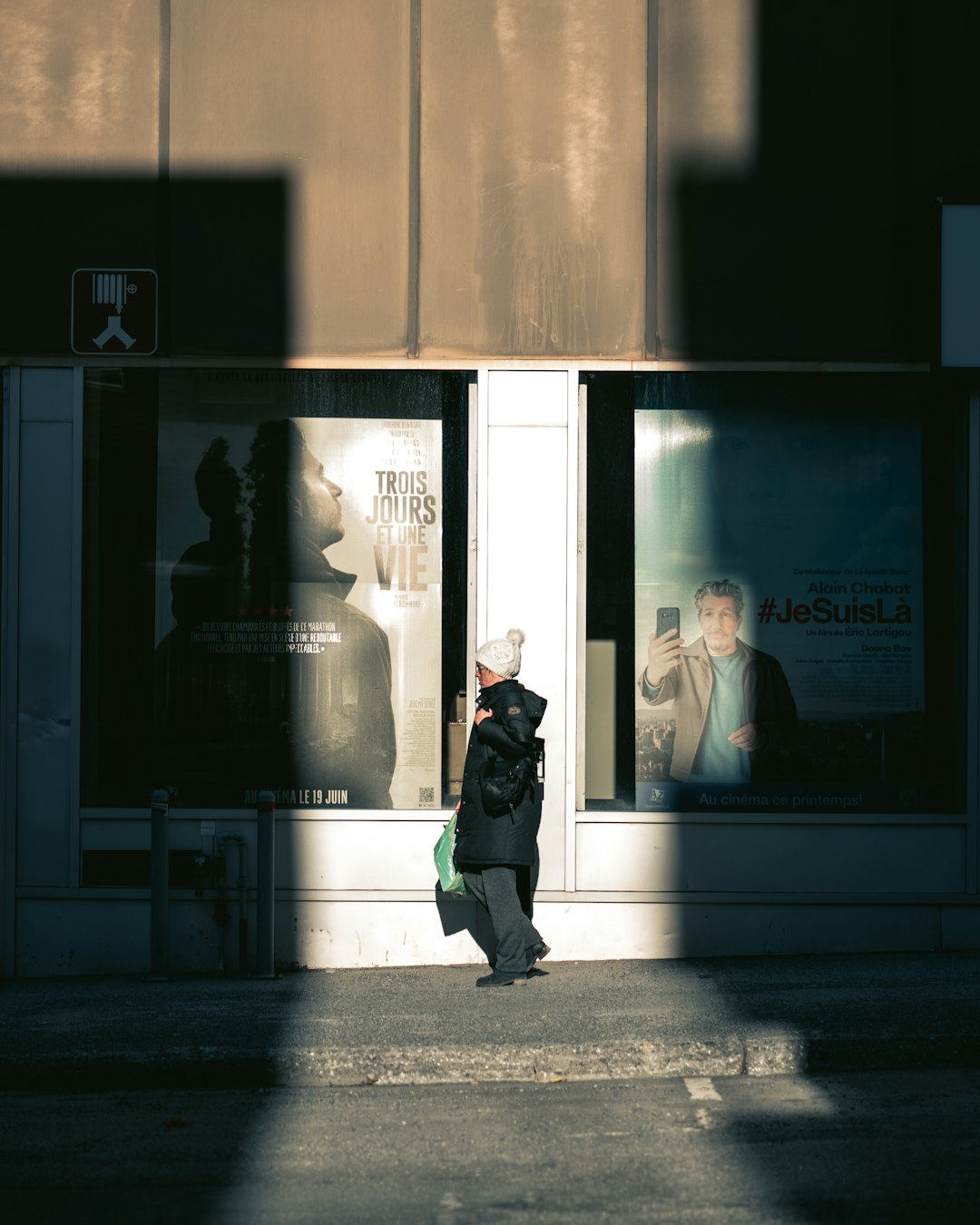 man in black jacket standing near glass window