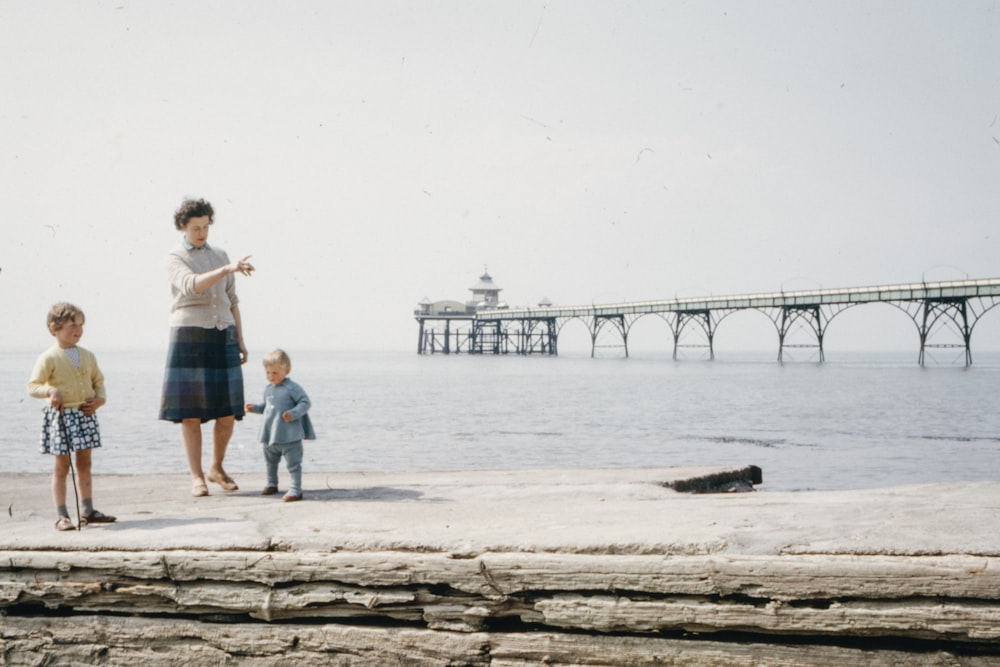 man and woman standing on brown rock near sea during daytime