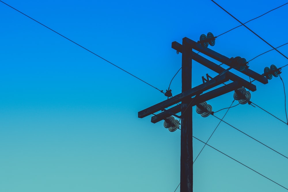 brown electric post under blue sky during daytime