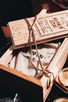 Close-up of a handcrafted wooden storage box with velvet-lined compartments holding luxury watches and jewellery.