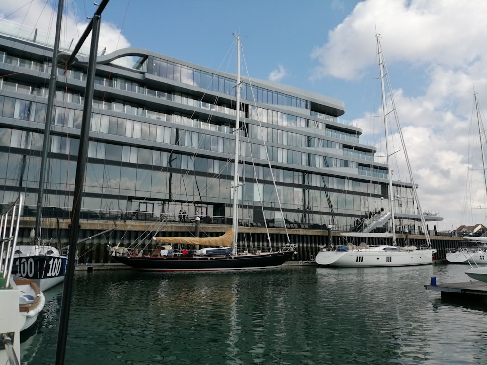 barco branco e marrom no mar perto do edifício de concreto branco durante o dia