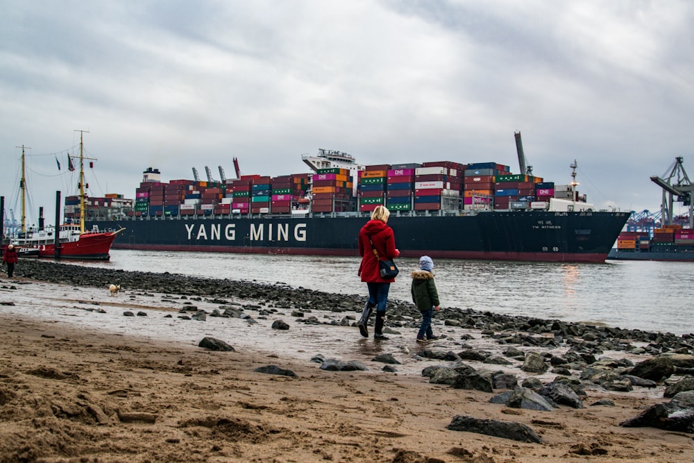 red cargo ship on sea under cloudy sky during daytime