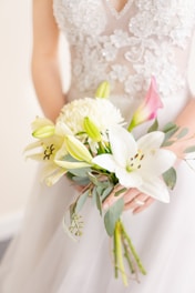 woman in white floral dress holding white flower
