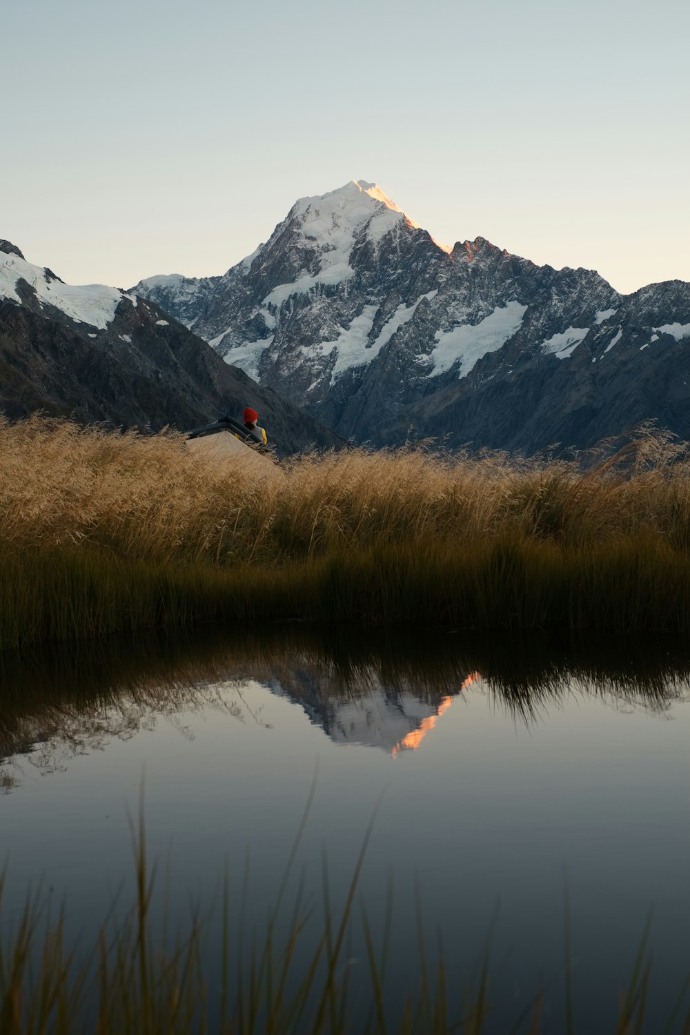 brown grass near lake and mountain range